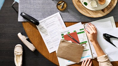 A woman sitting at a kitchen table with assorted Swingline products throughout it.